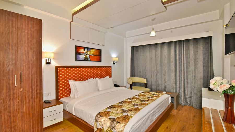 Bedroom with a wooden wardrobe next to it at DLS Hillcrest Resort, Shimla.